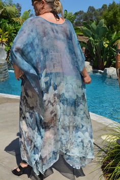 Feel feminine in this beautiful blue, exquisite silk caftan with soft, white flowers. Wear to the pool or beach over your favorite swimsuit. Wear as a dress with a slip or leggings and a cami top. One size. Fits small to large sizes. Elegant Beach Kimono With Floral Print, Blue Kimono For Poolside In Spring, Bohemian Sheer Kaftan For Beach, Elegant Flowy Kimono For The Beach, Sheer Kaftan For Summer Vacation, Blue Silk Kimono For Vacation, Elegant Blue Kimono For Vacation, Elegant Blue Kimono For Summer, Blue Silk Kaftan For Vacation