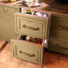 an open drawer in the middle of a kitchen counter