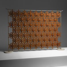 an intricately designed metal screen is displayed on a white surface with a gray background