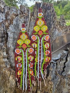 two beaded earrings hanging from a tree