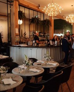 a group of people sitting at tables in a restaurant