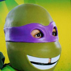 a close up of a person wearing a teenage mutant ninja mask and purple headband