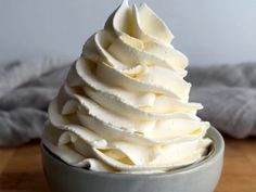 a bowl filled with whipped cream on top of a wooden table