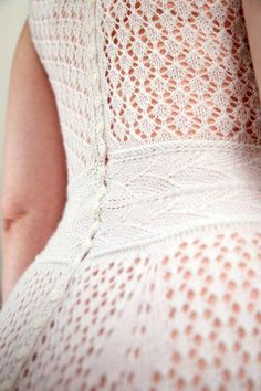 a woman wearing a white lacy dress and holding a cell phone