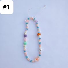 a beaded necklace with various colored beads and charms hanging from it's end