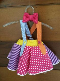 a dress hanging on a clothes hanger with polka dots and a red bow tie