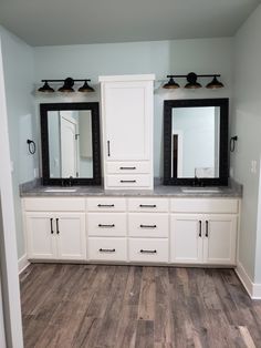 a bathroom with two mirrors and double sinks