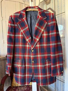 This fantastic jacket from Park Row is made from 55 per cent polyester and 45 per cent wool in white, dark red and navy blue plaid. It has the original buttons in the front and on the cuffs, three outside pockets and two inside pockets, and it's partially lined with dark blue silky lining. The measurements, taken with the coat lying flat, are: shoulder to shoulder, 19 inches; armpit to armpit, 24 inches; sleeves, 27 inches; length, 35 inches; bottom edge, 33 inches. In very good condition. Plaid Single-breasted Long Sleeve Suit, Plaid Wool Sport Coat, Fitted Plaid Wool Sport Coat, Tailored Plaid Sport Coat With Long Sleeves, Winter Plaid Single Breasted Sport Coat, Classic Plaid Blazer For Winter, Winter Single-breasted Plaid Blazer, Fitted Plaid Sport Coat With Long Sleeves, Retro Plaid Wool Blazer