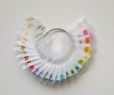 a keychain with several colors of paint in it on a white table top