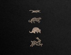 the four animals are depicted in silver on a black background, each with an animal's tail