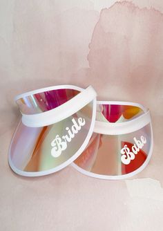 the bride and groom's personalized sunglasses are on display in front of a pink background