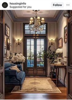 a living room filled with furniture and a chandelier hanging from the ceiling over a doorway