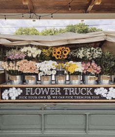 a flower truck with flowers in buckets on display