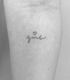 a small tattoo with the word love written in cursive writing