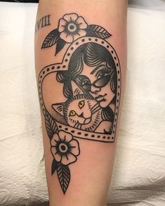 a woman with a cat in her heart shaped frame tattoo on the leg and arm