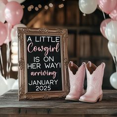 a little cowgirl is on her way arrival sign and cowboy boots with balloons in the background