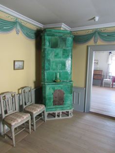 two chairs and a green cabinet in a room