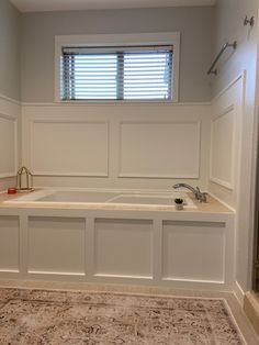 a bathroom with a sink, bathtub and window in the corner on the wall