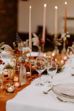 the table is set with wine glasses and candles