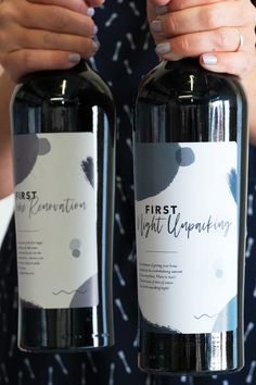 two bottles of wine being held by hands