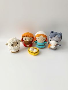 four crocheted stuffed animals sitting next to each other on a white surface,