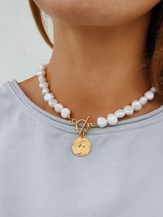 'Lucie' - a modern take on a classic pearl necklace. Beautiful freshwater baroque pearls combined with a gold toggle clasp and a 24k gold plated 925 sterling silver coin pendant. Pearls are symbolic of wisdom gained through experience. The gems are believed to offer protection, as well as attract good luck and wealth. Pearls are symbolic of the wearer's loyalty, generosity, integrity, and purity The surface of the pearls may have few bumps and ridges that indicate the natural origin of the pearls. The necklace is approximately 42 cm in length, lenght varies slightly due to natural size differences in pearls. Wear it alone or layered with other necklaces from our collection: https://www.etsy.com/shop/hippieplumedesigns?section_id=14540137&ref=shopsection_leftnav_2 How to take care of your j Pearl Necklace With Gold, Gold Coin Pendant, Jewelry Necklace Simple, Ancient Greek Jewelry, Gold Medallion Necklace, Pearl Necklace Choker, Classic Pearl Necklace, Greek Jewelry, Coin Pearls