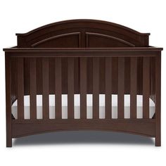 a brown crib with white sheets on the bottom and side rails, in front of a white background