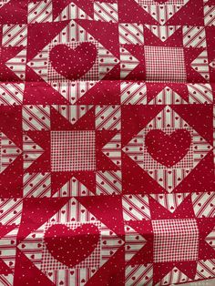 a red and white quilt with hearts on it