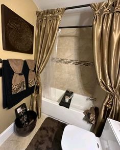 a bathroom with a tub, toilet and shower curtained in leopard print on the curtains