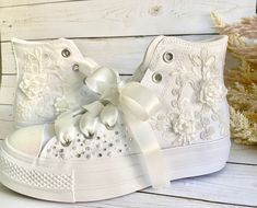 a pair of white high top sneakers with bows