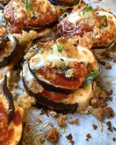 several stuffed eggplant pizzas with cheese and tomato sauce on a baking sheet