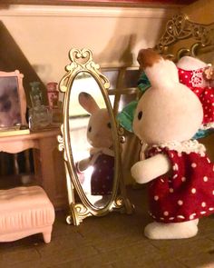 a stuffed animal is standing in front of a mirror