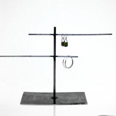 a pair of earrings are hanging from a metal stand with two rings attached to it