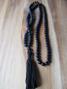 "108 Bead Matte Black Onyx and Black Lava Bead Mala This traditional 108 bead mala features a stunning combination of matte black onyx beads and black lava beads. It is finished off with a hand tied matching black tassel. Excellent for meditation or to wear as a beautiful long necklace. Materials: 8mm Matte Black Onyx Beads 8mm Black Lava Beads Black Knotting Cord Cotton Tassel Size info: 108 bead mala plus guru bead measures approximately 35 inches in circumference with a 3\" tassel. * All jewe Bohemian Black Hand Knotted Jewelry, Black Bohemian Beads For Meditation, Bohemian Black Beads For Meditation, Bohemian Black Hand-strung Mala, Black Bohemian Mala With Round Beads, Bohemian Black Mala For Healing, Bohemian Black Mala With Round Beads, Bohemian Black Beaded Mala, Black Hand-knotted Jewelry With Round Beads