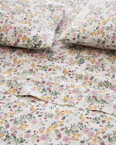 an image of a bed with floral sheets and pillowcases on top of it