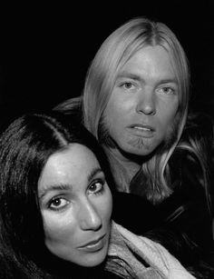 two women are posing for a black and white photo with one woman looking at the camera