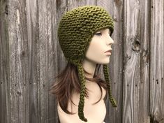 "Knit Hat Style: Garter Earflap Helmet - a chunky knit hat with ear flaps and knitted ties, for women, men and teens. Color: This sample hat is shown in Cilantro, an olive green. Sizes: One size fits average teen or adult head size of 20\" to 23\" (50.5 cm to 58 cm). Fiber Content: 80% acrylic, 20% wool Characteristics: Whimsical, chunky, very soft, warm and cozy. Care Instructions: Hand wash, dry flat. Every item from Pixiebell is handmade and knit or crocheted to order, unless otherwise stated Hat With Ear Flaps, Earflap Hat, Chunky Knit Hat, Mens Hat, Pixie Hat, Handmade Knitwear, Womens Hat, Hat Knit, Winter Hats For Men