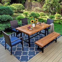 a wooden table sitting on top of a blue and white rug next to a bench