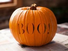 a carved pumpkin sitting on top of a newspaper