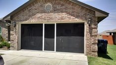 a brick house with two garage doors open