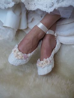 the bride's shoes are all white and have flowers on them, while she is wearing her wedding dress