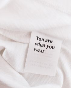 a white shirt with a tag that says you are what you wear on the label