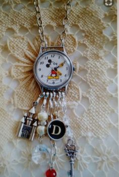 a clock with charms attached to it sitting on a table