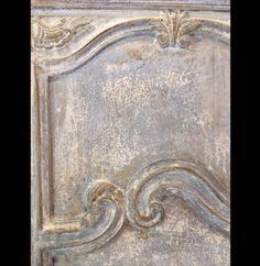 an old, weathered metal panel with ornate designs