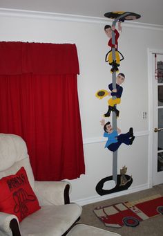 a living room with a white chair and red drapes hanging from the ceiling next to a window