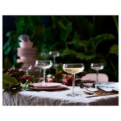 a table topped with two wine glasses and plates