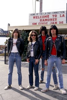 four young men standing in front of a theater