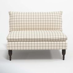 a white and black checkered couch with wooden legs