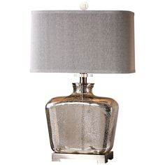 a glass table lamp with a silver shade on it and a white light in the middle