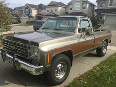 an older pickup truck parked in front of some houses